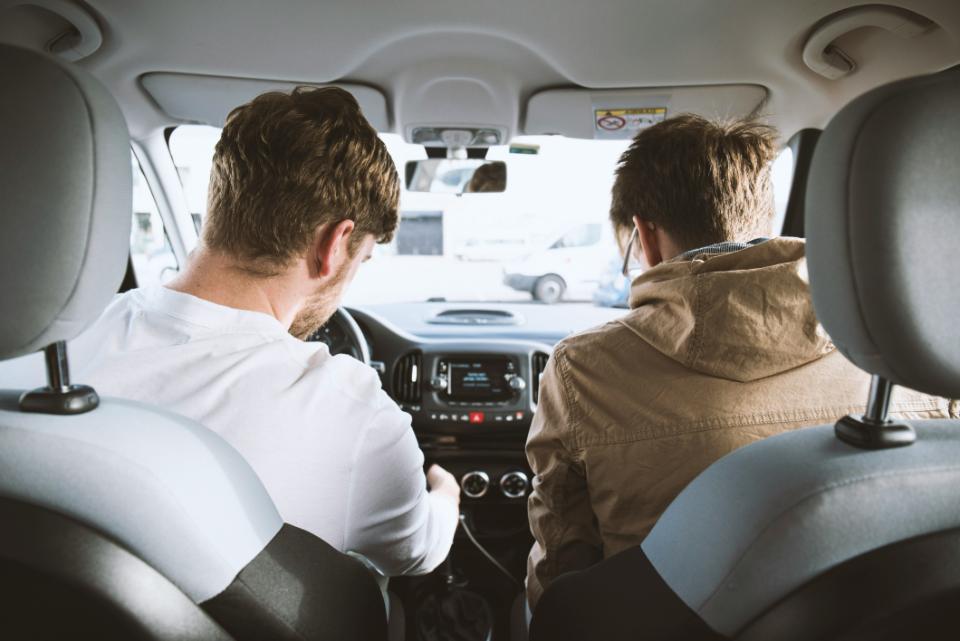 Two men sitting inside a car.