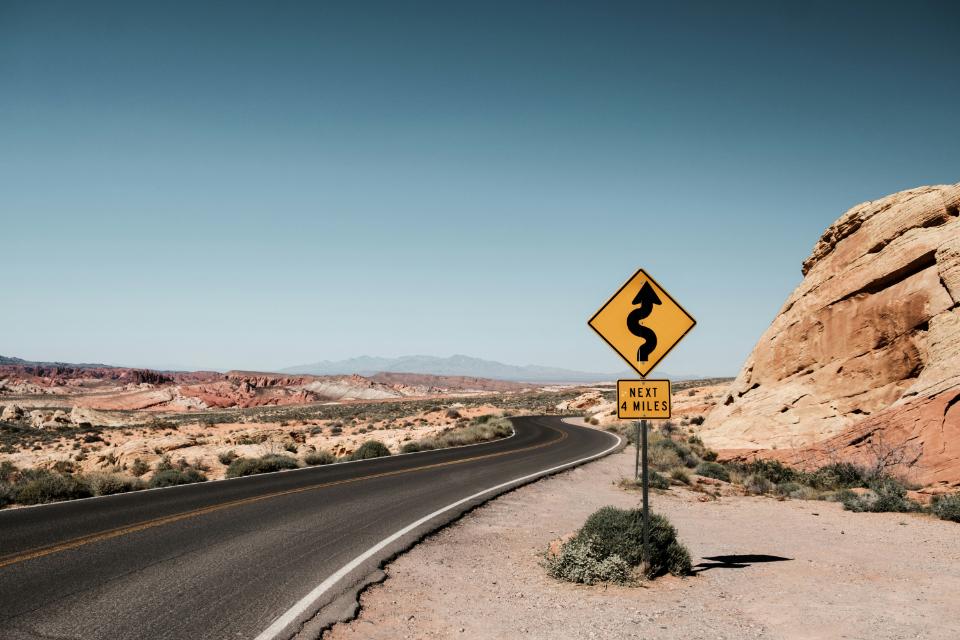 Desert road with next-4-miles curve warning